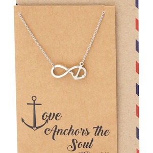 Può includere: Collana color argento con un ciondolo a forma di simbolo dell'infinito e ancora. La collana è esposta su una carta marrone con la scritta "Love Anchors the Soul" e "Ebrei 6:19". La carta ha un bordo decorativo.