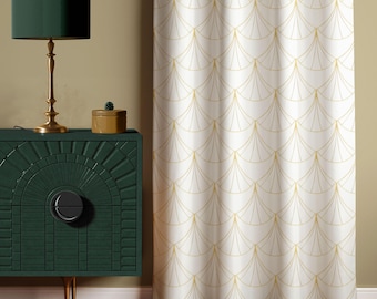 Puede incluir: Un mueble verde oscuro con una lámpara dorada y una pequeña caja de madera. Una cortina blanca con un patrón dorado en forma de abanico está a la derecha. El mueble tiene un tirador negro y patas doradas.