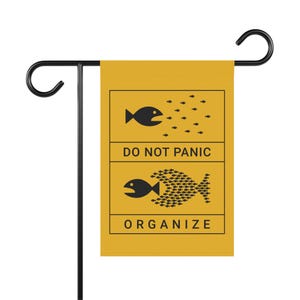 Puede incluir: Una bandera de jardín amarilla con ilustraciones de peces negros y el texto "No te asustes" y "Organiza".