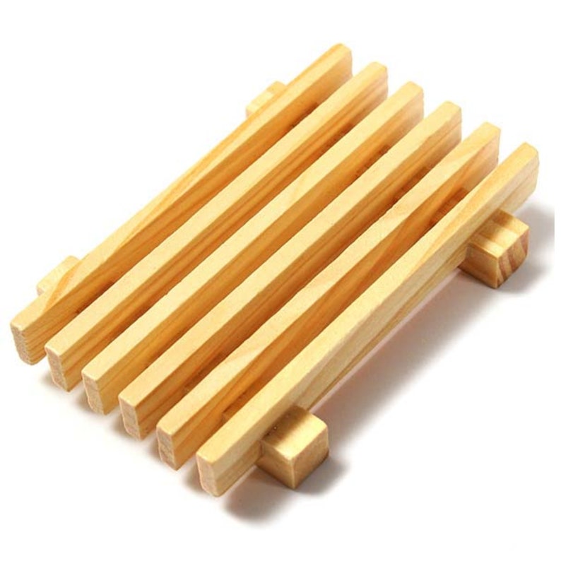 May include: A wooden soap dish with five slats for draining water. The dish is made of natural wood and has a light brown color.