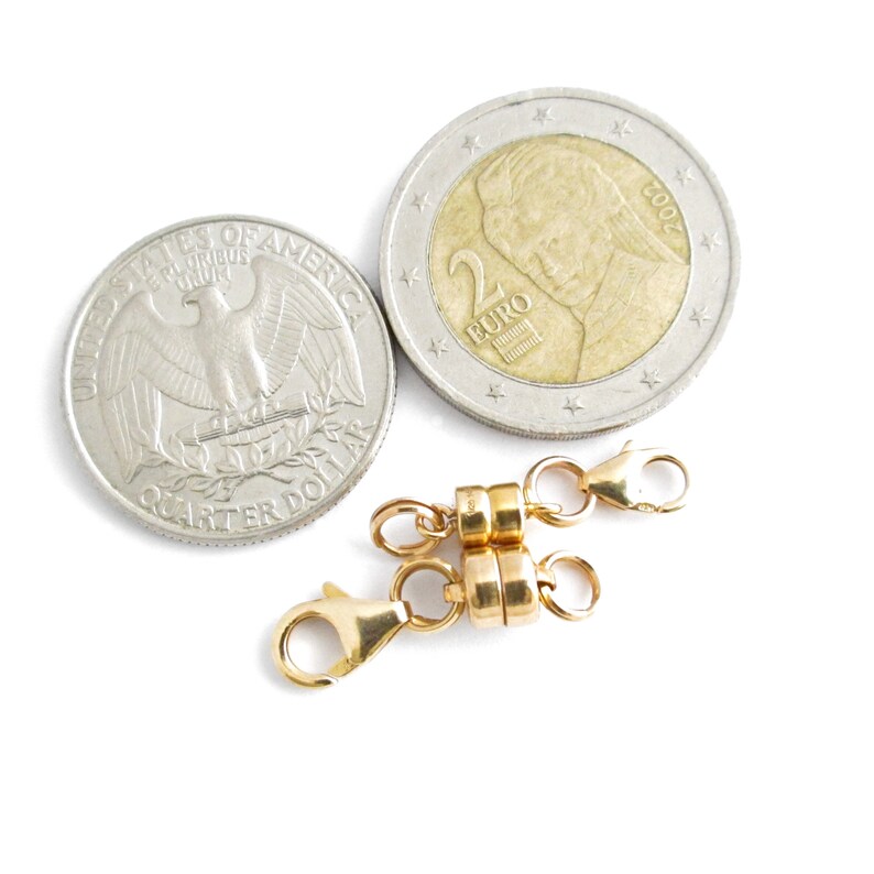 May include: A gold-toned magnetic clasp for a necklace or bracelet. The clasp is shown next to a US quarter and a 2 Euro coin to show its size.