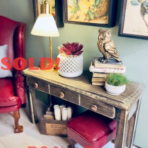 May include: Miniature dollhouse furniture set with a desk, stool, and chair. The desk has a distressed wood finish and copper-colored drawer pulls. A gold owl figurine sits on a stack of books. The words "SOLD!" and "DO Not Buy Sample of Work!" are visible.