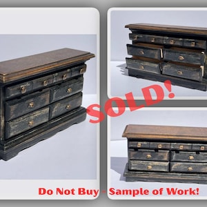 May include: Miniature wooden dresser with a distressed black finish and gold-toned hardware. The top is a contrasting brown color. The image includes the text "SOLD!" and "Do Not Buy - Sample of Work!"