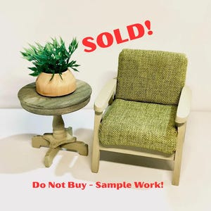 May include: Miniature dollhouse furniture set featuring a green upholstered armchair and a small round side table. The table has a distressed finish and supports a small plant in a wooden pot. The word "SOLD!" is written in red.