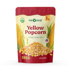 May include: A bag of Pop N Dulge yellow popcorn. The bag is red and cream-colored, with the words "Yellow Popcorn" prominently displayed. The bag also features images of corn on the cob and a pile of popcorn kernels. The bag contains 1 pound of popcorn.