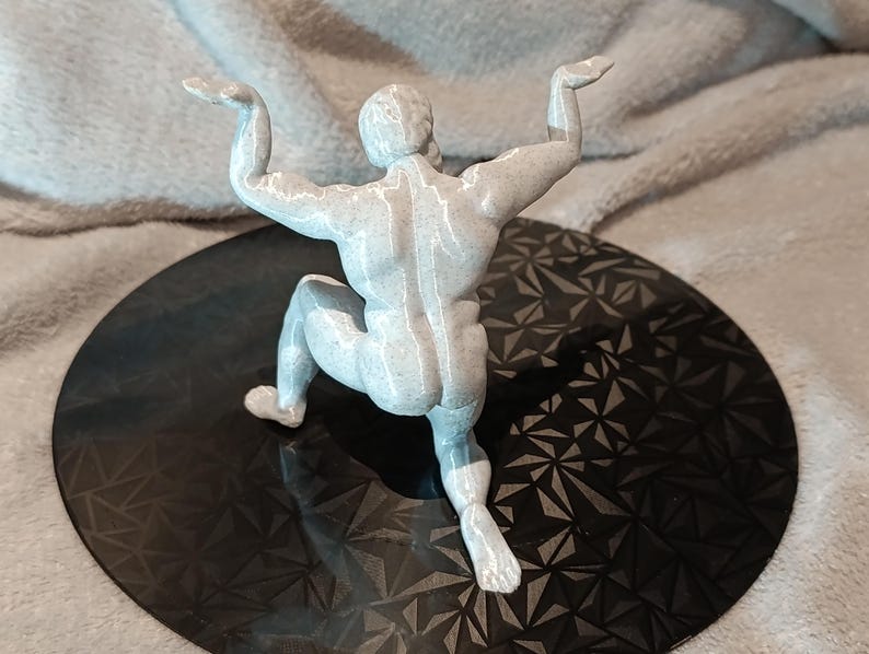 K&ouml;nnte beinhalten: Eine wei&szlig;e, 3D-gedruckte Figur eines Menschen in einer hockenden Pose mit erhobenen Armen &uuml;ber dem Kopf.
