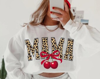 May include: White sweatshirt with the word "MAMA" printed in leopard print with a red bow and two red cherries underneath.