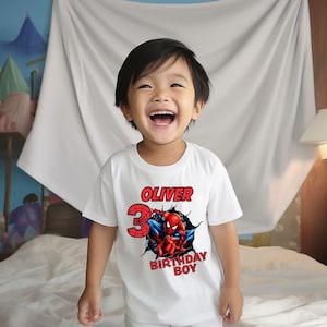 Op de afbeelding: Een wit T-shirt met een rode en blauwe Spiderman-afbeelding, het nummer 3 en de tekst "Oliver Birthday Boy".
