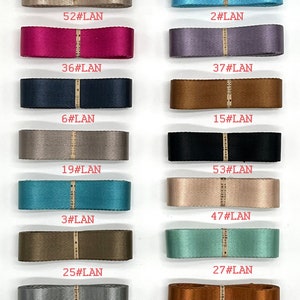 May include: A collection of 12 different coloured ribbon spools with numbers and the text "#LAN" printed on each spool.