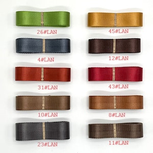 May include: A collection of ten different coloured ribbon samples, each with a number and the text "#LAN" printed on a white label. The ribbons are arranged in two rows of five, with the numbers increasing from left to right.