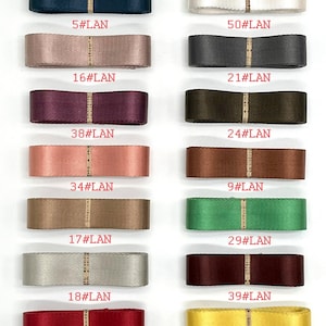 May include: A collection of 12 different coloured ribbon spools with numbers and the text "#LAN" printed on each spool.
