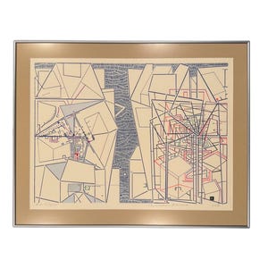 May include: Framed abstract art print featuring geometric shapes and lines in black, red, and blue on a beige background. The artwork is encased in a silver frame with a beige mat.