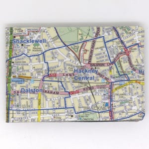 Könnte beinhalten: Eine rechteckige Geldbörse mit einer detaillierten Karte des Stadtteils Hackney Central in London. Die Karte enthält Straßennamen, Straßen und Sehenswürdigkeiten in Beige, Blau und Grün.
