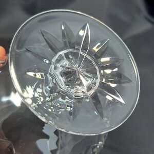 May include: A clear crystal glass base featuring a starburst pattern cut into the underside. The circular base has a faceted design radiating from the centre, with the word Galway etched into the glass surface near the outer edge of the rim.
