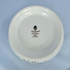 Puede incluir: Cuenco blanco de porcelana fina Wedgwood Avebury. El cuenco tiene un borde ancho y un interior ligeramente curvado. El logotipo de Wedgwood y "Made in England" est&aacute;n impresos en negro. El cuenco tiene un dise&ntilde;o floral alrededor del borde.