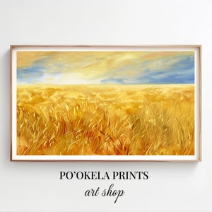 Puede incluir: Una pintura de un campo de trigo dorado bajo un cielo nublado. La pintura está enmarcada en un marco de madera claro. El texto "PO'OKELA PRINTS art shop" está en la parte inferior de la imagen.