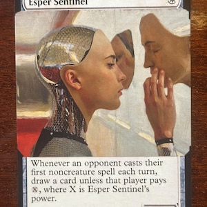 May include: A Magic: The Gathering card featuring the artwork of a woman with a metallic head and a person touching her face. The card is titled "Esper Sentinel" and includes game text and a power/toughness of 1/1.