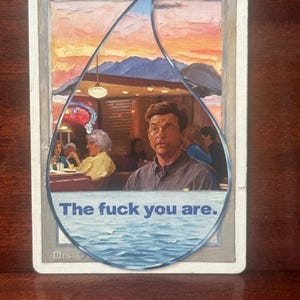 May include: A custom-painted "Island" Magic: The Gathering card. The card features a surreal image of a diner scene inside a water droplet shape, with the text "The fuck you are."