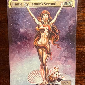 May include: A fantasy trading card depicting a woman with long red hair standing on a seashell with a cat. The card is titled "Jinnie Fay, Jetmir's Second" and has a power and toughness rating of 3/3.