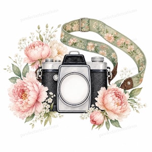 May include: A black and silver vintage-style camera surrounded by large, soft pink peony flowers and green leaves. A long, sage green camera strap with a delicate floral pattern loops above the camera, featuring metal hardware and brown leather ends.