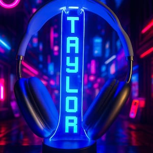 May include: A blue neon headphone display with the name "TAYLOR" vertically illuminated. The base displays "FONTI" in white. The background features a futuristic, neon-lit cityscape.