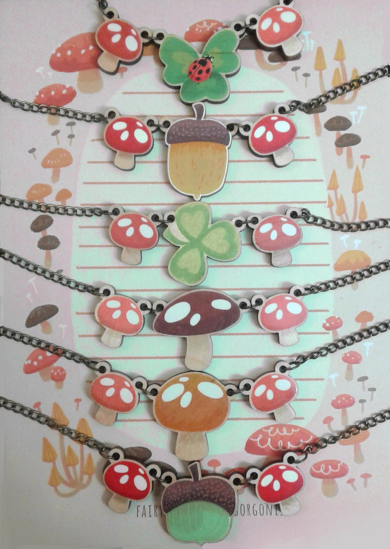 May include: Six necklaces with wooden charms featuring mushrooms, acorns, clovers, and butterflies. The charms are painted in various colors, including red, green, brown, and white. The necklaces are made with a brown chain.