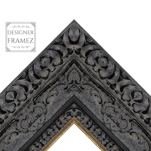 May include: A dark charcoal gray picture frame corner with intricate, raised scrollwork and floral carvings. The frame features a deep, textured finish with subtle gold-toned inner edges. The text "DESIGNER FRAMEZ" is visible in the upper left corner.