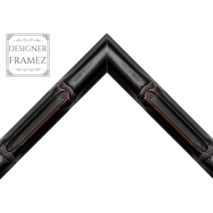 May include: A black picture frame corner sample with a bamboo-inspired texture and subtle red highlights in the grooves. The frame features a mitered corner joint and includes a logo in the upper left corner that reads DESIGNER FRAMEZ.