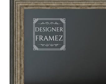 Puede incluir: Un marco rectangular con un acabado de madera oscura desgastada y un perfil escalonado de varias capas. El centro presenta una superficie negra con un logotipo gráfico blanco que dice DESIGNER FRAMEZ dentro de un borde cuadrado.