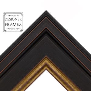 May include: Close-up of a corner of a black picture frame with a gold inner edge and a brown accent. The frame has the text "DESIGNER FRAMEZ" in a decorative box.