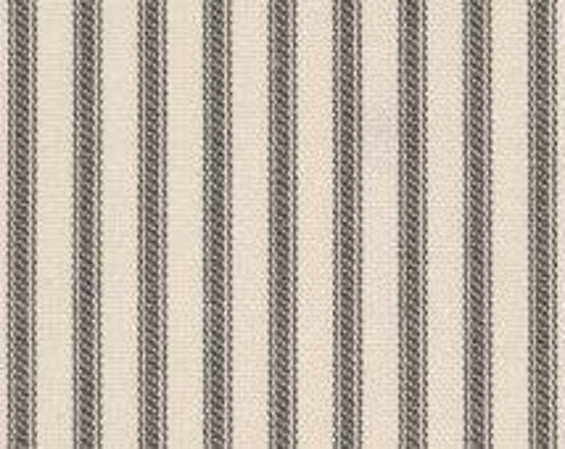 Puede incluir: Una tela textil con un patr&oacute;n repetitivo de rayas verticales. El dise&ntilde;o consiste en una alternancia de bandas anchas de color crema y rayas m&aacute;s estrechas de color gris carb&oacute;n oscuro con una sutil textura tejida en toda la superficie.
