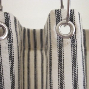 close up photograph of a black and cream stripe fabric shower curtain