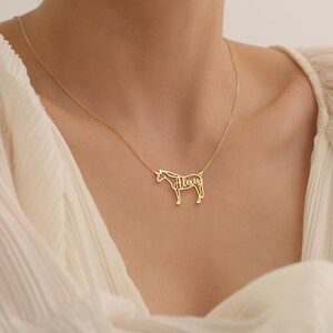 May include: Gold necklace with a unicorn pendant. The unicorn is outlined and the name "Alexis" is spelled out within the outline.
