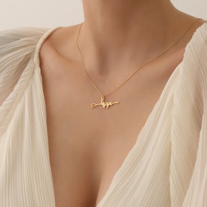 May include: A gold necklace with a pendant that says "hope" with an arrow through the word.