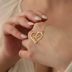 May include: Gold-toned necklace with a heart-shaped pendant featuring a horse silhouette and the name "Charlie" inscribed inside.