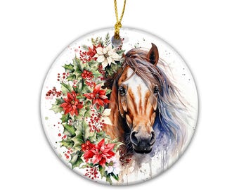 May include: A round ceramic ornament featuring a watercolor illustration of a brown horse head with a white blaze, surrounded by red poinsettias, green holly leaves, and red berries. The ornament hangs from a gold string loop at the top.