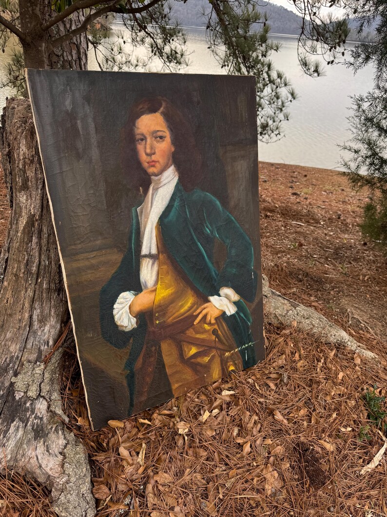 Pode incluir: Uma pintura de retrato antigo de uma pessoa jovem com um casaco de veludo verde, colete dourado e gravata branca. O retrato &eacute; contra um fundo escuro, com as m&atilde;os do sujeito na cintura. A pintura &eacute; exibida ao ar livre, encostada a um tronco de &aacute;rvore.