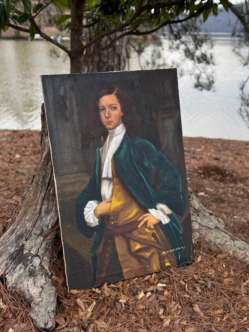 Pode incluir: Pintura a &oacute;leo de uma pessoa jovem com casaco verde-azulado, colete dourado e camisa branca. O retrato &eacute; ambientado em um fundo escuro, com as m&atilde;os do sujeito apoiadas na cintura. A pintura &eacute; assinada "H. HEANE" no canto inferior direito.