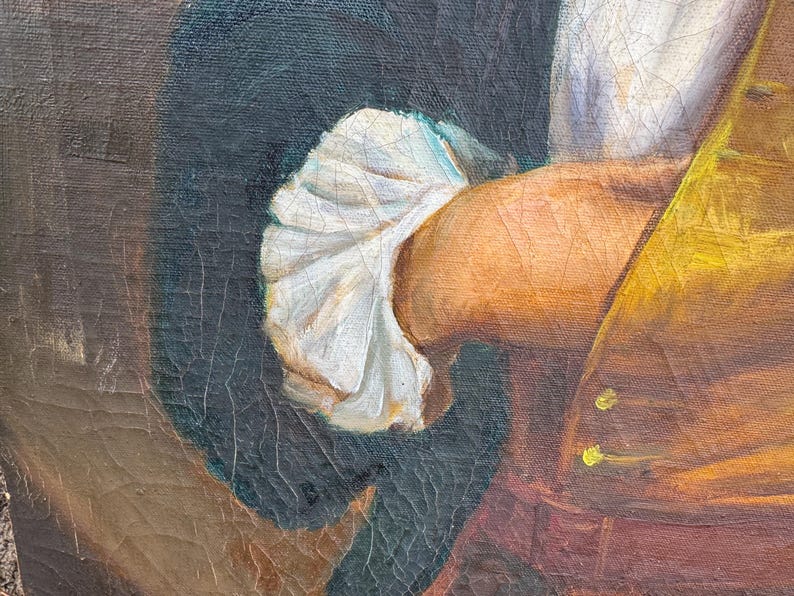 Pode incluir: Close-up de um fragmento de pintura a &oacute;leo vintage. A imagem mostra o bra&ccedil;o e a m&atilde;o de uma pessoa, com uma manga branca com babados. A pessoa est&aacute; vestindo um colete amarelo e um casaco escuro. A pintura tem rachaduras vis&iacute;veis.