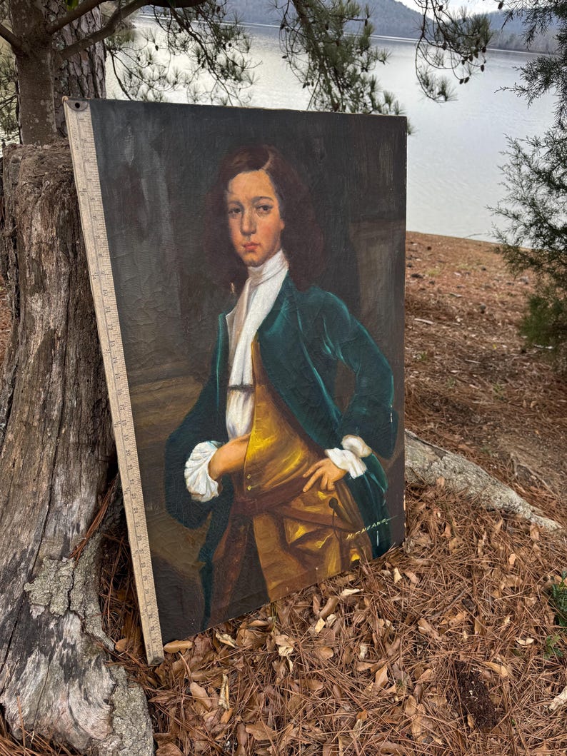 Pode incluir: Uma pintura de retrato antigo de uma pessoa jovem com uma jaqueta de veludo verde, colete dourado e camisa branca com babados. A pintura &eacute; definida contra um fundo escuro, com uma r&eacute;gua vis&iacute;vel ao longo da borda. O sujeito tem cabelo castanho comprido e est&aacute; olhando diretamente para o espectador.