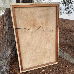 Pode incluir: Verso de uma pintura em tela emoldurada. A tela &eacute; bege claro, esticada sobre uma moldura de madeira. A moldura tem um tom de madeira natural com uma borda creme. Um fio preto &eacute; esticado na parte de tr&aacute;s.