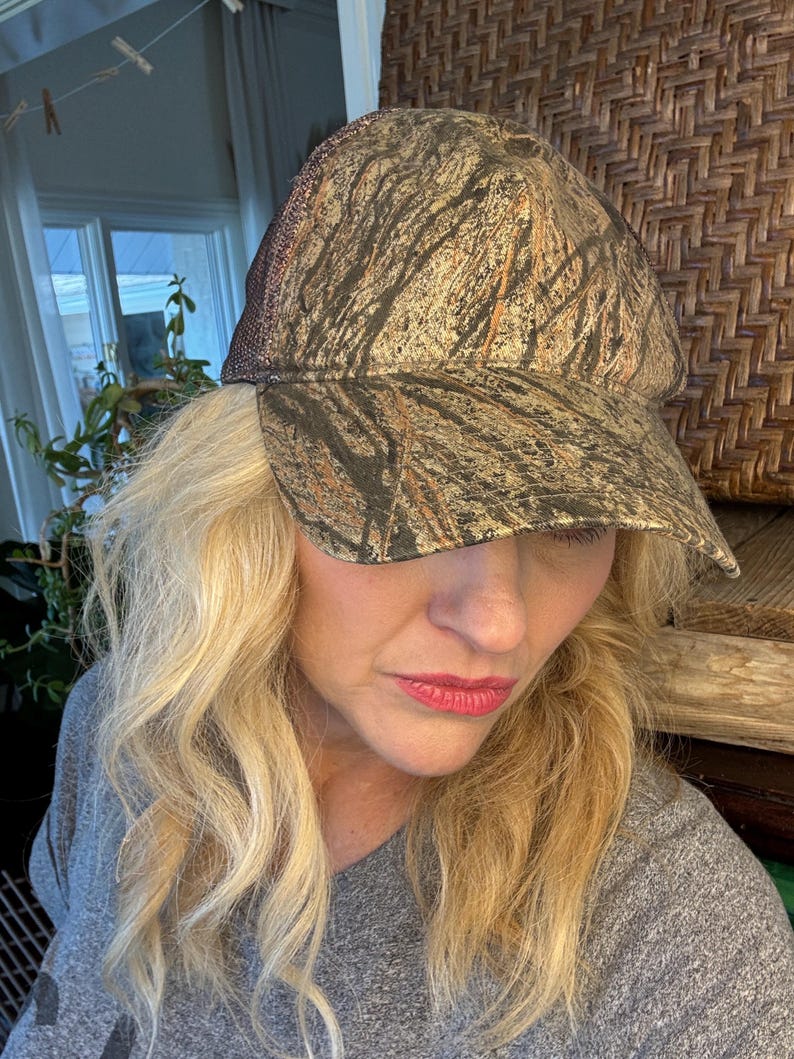 Puede incluir: Gorra de b&eacute;isbol de camuflaje con un patr&oacute;n marr&oacute;n y verde. La gorra tiene una parte trasera de malla y una visera curva. El sombrero est&aacute; dise&ntilde;ado para actividades al aire libre y proporciona protecci&oacute;n solar.