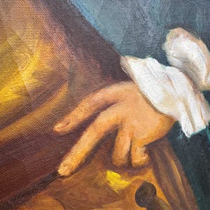 Pode incluir: Pintura a &oacute;leo que retrata uma m&atilde;o com uma manga branca com babados, em um fundo de tons marrons e dourados quentes. A obra apresenta uma pe&ccedil;a de roupa verde escura e um microfone, sugerindo um tema hist&oacute;rico ou teatral.
