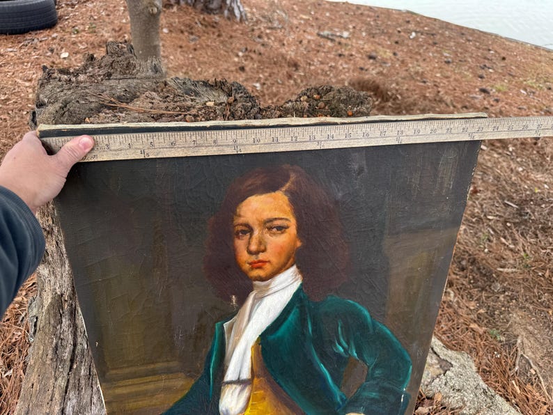 Pode incluir: Um retrato antigo de uma pessoa com um casaco verde, gola branca e colete amarelo. A pintura &eacute; segurada por uma m&atilde;o, e uma r&eacute;gua &eacute; colocada no topo. O sujeito tem cabelo castanho e uma express&atilde;o s&eacute;ria.