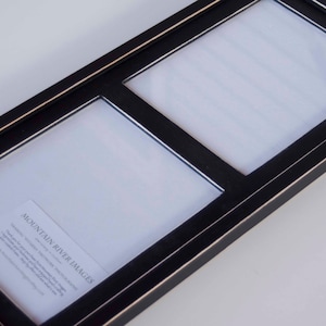 May include: Black picture frame with three openings for photos. The frame has a thin gold trim around the edges. The frame is made of wood and has a distressed finish. The frame is labeled "Mountain River Images".