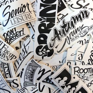 May include: A collection of black and white stickers with various designs and text, including "Senior Leisure", "Don't Forget!", "Spring", "Autumn", "West", "Rooted", and "Is in the Air".