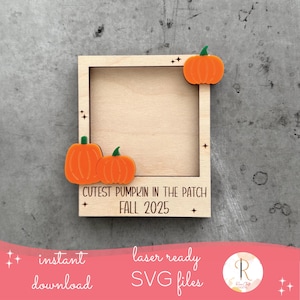 May include: A wooden frame with three orange pumpkin cutouts and the text "CUTEST PUMPKIN IN THE PATCH FALL 2025". The frame has a light brown color and is decorated with small star shapes.