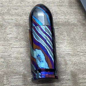 May include: A blue, purple and silver bullet-shaped pen with a swirling pattern.