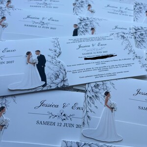 Könnte beinhalten: Weiße Hochzeitseinladungen mit schwarzen Tuscheillustrationen von Braut und Bräutigam, floralen Akzenten und dem Text Jessica & Enzo Samedi 12 Juin 2027. Die Karten enthalten gedruckte Details zu einer Hochzeitszeremonie und einem Empfang.