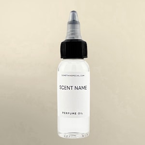 May include: A clear plastic bottle containing perfume oil with a black screw-on cap and a transparent pointed applicator tip. The white label features the text SOMETHINSPECIAL.COM, SCENT NAME, and PERFUME OIL in black sans-serif lettering.